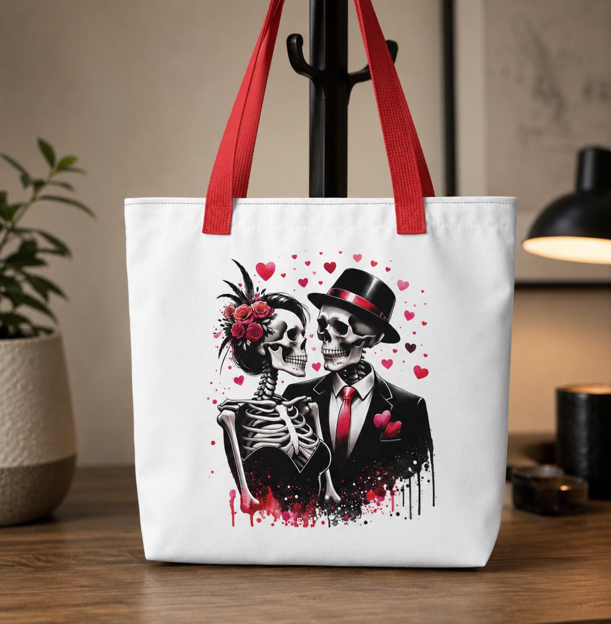 White tote bag with red handles featuring a romantic gothic skeleton couple design with roses, hearts, and elegant black-and-red formal attire. Stylish alternative fashion accessory perfect for gothic lovers, Halloween style, everyday shopping, and dark aesthetic gifts.