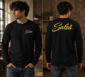 Male model wearing a black long sleeve salsa shirt featuring gold “Salsa” script logo on the front and oversized back graphic with crown detail. Stylish Latin dance apparel for salsa dancers, social dance events, and salsa lifestyle fashion.