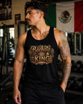 Male model wearing a black “Bachata King” graphic tank top with gold crown artwork in a gym setting. Stylish bachata dance apparel for Latin dance lovers, social dancers, fitness enthusiasts, and bachata lifestyle fashion.