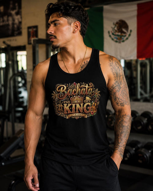 Male model wearing a black “Bachata King” graphic tank top with gold crown artwork in a gym setting. Stylish bachata dance apparel for Latin dance lovers, social dancers, fitness enthusiasts, and bachata lifestyle fashion.